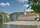 Das Kloster Weltenburg mit seinem Kieselstrand und der Donau, die  im Hintergrund durch den Donaudurchbruch hindurchfließt.